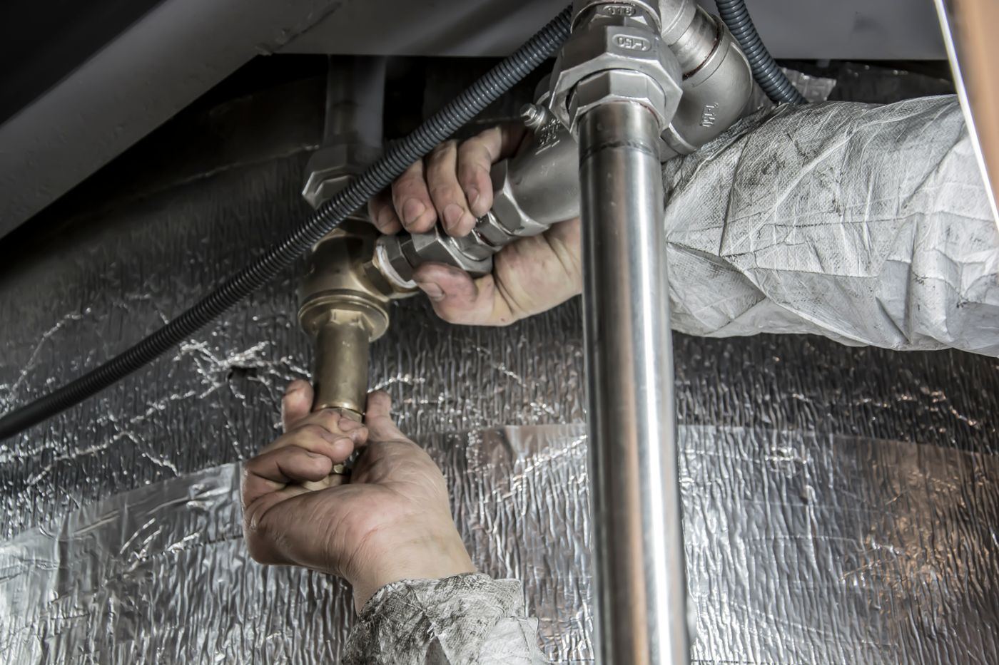 A plumber tightening a fitting