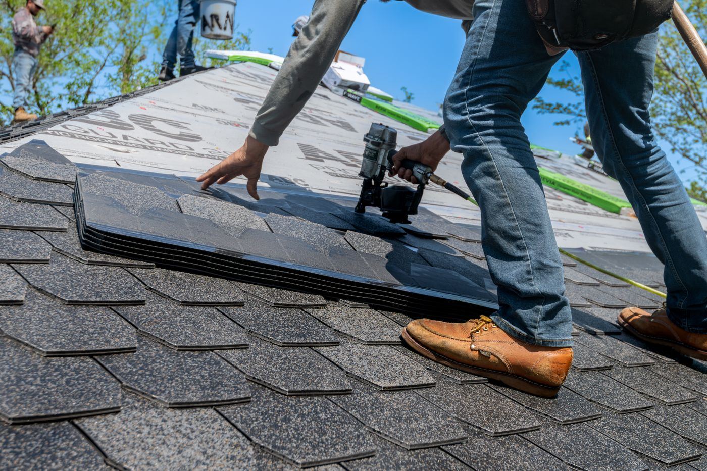 A roofer laying shingles